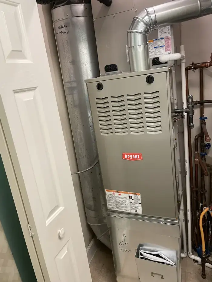 A newly installed Bryant furnace with flue piping in a basement